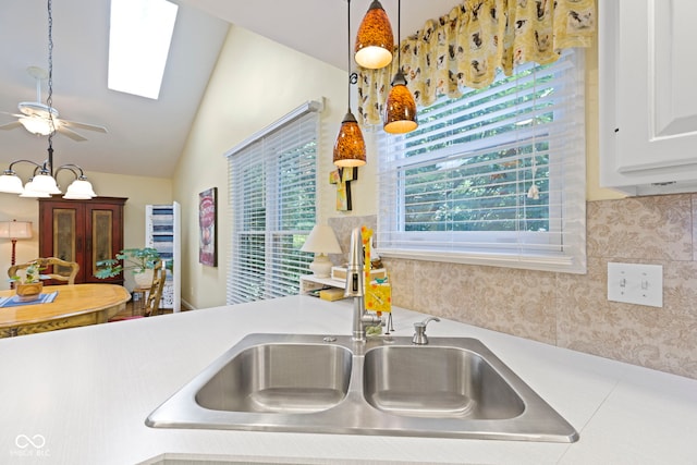 1114 Clairborne Ct, Indianapolis, IN 46280 - kitchen with vaulted ceiling, light countertops, a ceiling fan, white cabinetry, and decorative light fixtures