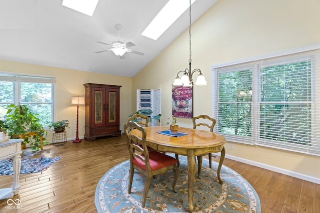 1114 Clairborne Ct, Indianapolis, IN 46280 - dining room featuring a skylight, high vaulted ceiling, light wood-style floors, a ceiling fan, and a chandelier