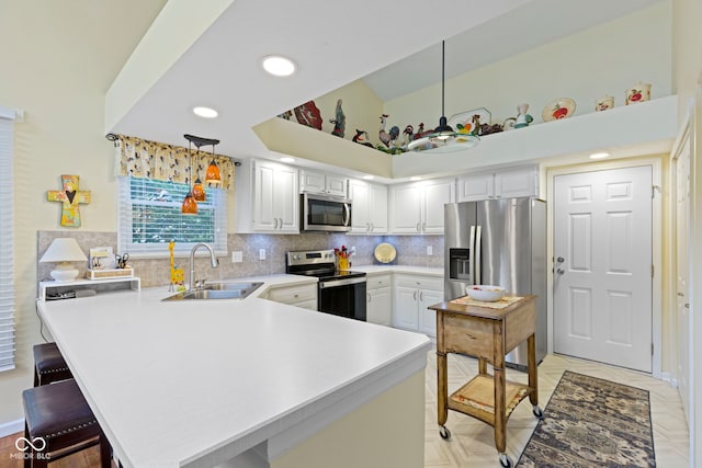 1114 Clairborne Ct, Indianapolis, IN 46280 - kitchen with stainless steel appliances, a peninsula, light countertops, backsplash, and hanging light fixtures