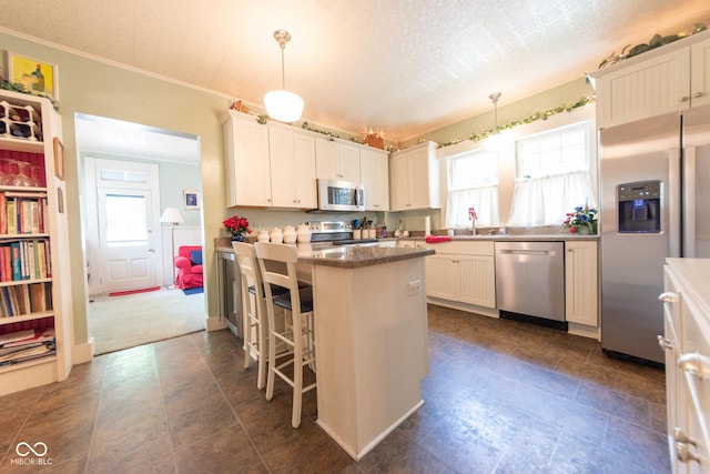 1022 Franklin St, Columbus, IN 47201 - kitchen with stainless steel appliances, healthy amount of natural light, a breakfast bar area, decorative light fixtures, and crown molding