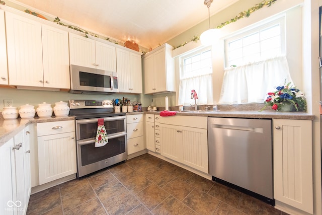 1022 Franklin St, Columbus, IN 47201 - kitchen with stainless steel appliances, pendant lighting, dark stone finish flooring, and light countertops