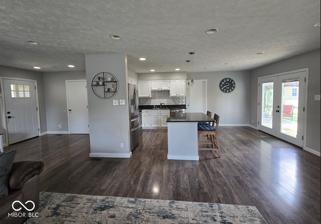 8401 Culpeper Dr, Indianapolis, IN 46227 - kitchen featuring open floor plan, dark countertops, a kitchen bar, white cabinetry, and stainless steel appliances