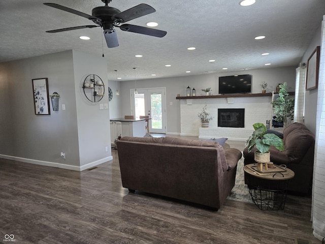 8401 Culpeper Dr, Indianapolis, IN 46227 - living area featuring dark wood-type flooring, a brick fireplace, recessed lighting, a ceiling fan, and a textured ceiling