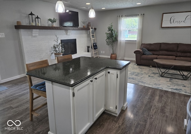 8401 Culpeper Dr, Indianapolis, IN 46227 - kitchen with dark wood-style floors, white cabinets, a fireplace, a center island, and recessed lighting