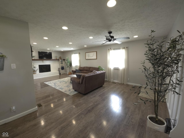 8401 Culpeper Dr, Indianapolis, IN 46227 - living room featuring plenty of natural light, a fireplace with raised hearth, a ceiling fan, recessed lighting, and a textured ceiling
