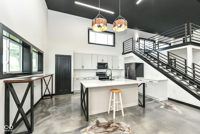 5400 E 200 S, Whitestown, IN 46075 - kitchen featuring black appliances, a towering ceiling, concrete flooring, and light countertops