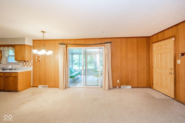 10104 Sycamore Ln, Indianapolis, IN 46239 - unfurnished living room featuring wood walls, light carpet, and a chandelier