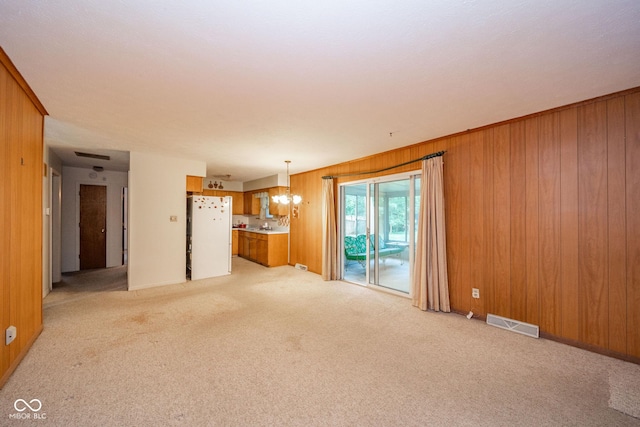 10104 Sycamore Ln, Indianapolis, IN 46239 - unfurnished living room featuring light colored carpet, a chandelier, and wood walls