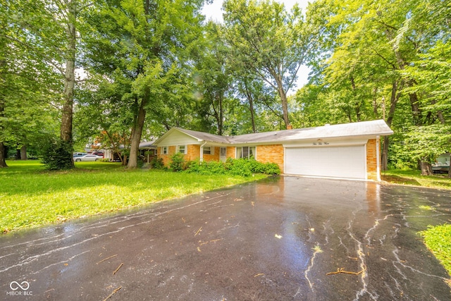 10104 Sycamore Ln, Indianapolis, IN 46239 - view of front of property featuring driveway, an attached garage, brick siding, and a front yard
