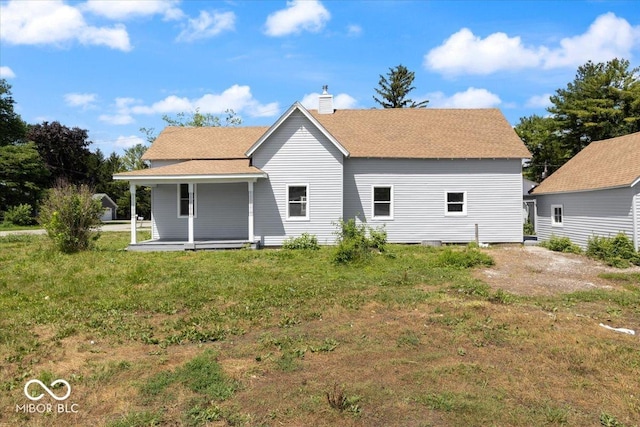 304 W Jefferson St, Kirklin, IN 46050 - back of house with a chimney, covered porch, a lawn, and roof with shingles