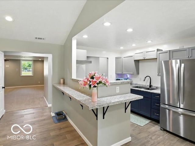 11093 N Pheasant Run, Fairland, IN 46126 - kitchen featuring freestanding refrigerator, a breakfast bar, a peninsula, recessed lighting, and light wood-style flooring