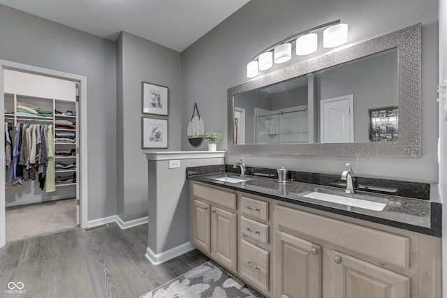 1454 Heron Ridge Blvd, Greenwood, IN 46143 - bathroom with wood finished floors, a stall shower, double vanity, and a walk in closet