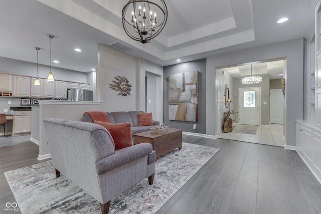 1454 Heron Ridge Blvd, Greenwood, IN 46143 - living area with a chandelier, wood finished floors, a raised ceiling, and recessed lighting