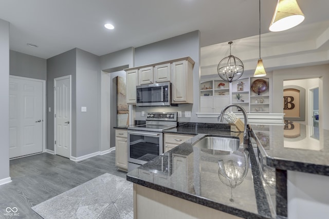 1454 Heron Ridge Blvd, Greenwood, IN 46143 - kitchen featuring stainless steel appliances, wood finished floors, decorative light fixtures, a peninsula, and dark stone countertops