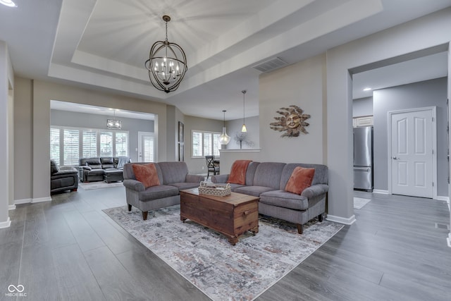 1454 Heron Ridge Blvd, Greenwood, IN 46143 - living room with a chandelier, a tray ceiling, and wood finished floors