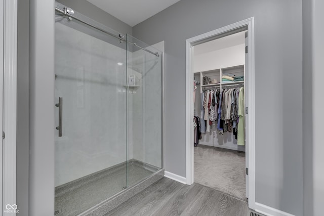 1454 Heron Ridge Blvd, Greenwood, IN 46143 - bathroom featuring a shower stall, a walk in closet, and wood finished floors