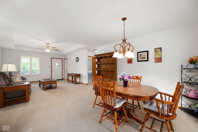 114 Asbury Dr, Anderson, IN 46013 - dining space with light colored carpet, a chandelier, ceiling fan, and a raised ceiling