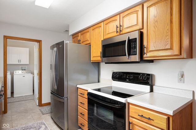 114 Asbury Dr, Anderson, IN 46013 - kitchen featuring appliances with stainless steel finishes, separate washer and dryer, light countertops, and light tile patterned floors