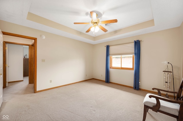 114 Asbury Dr, Anderson, IN 46013 - spare room with a tray ceiling, light carpet, and ceiling fan