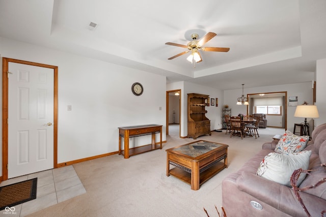 114 Asbury Dr, Anderson, IN 46013 - living area featuring a raised ceiling, a ceiling fan, light colored carpet, and a chandelier