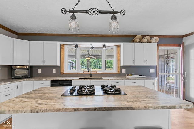 6092 N Jack Morgan Rd, Austin, IN 47102 - kitchen with gas cooktop, crown molding, white cabinetry, a kitchen island, and a textured ceiling