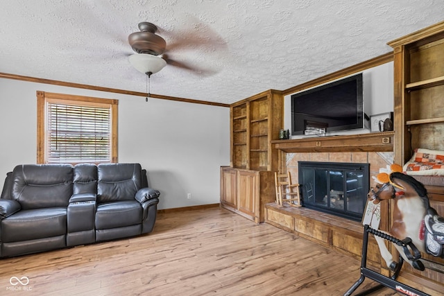 6092 N Jack Morgan Rd, Austin, IN 47102 - living area featuring ceiling fan, light wood-style floors, built in features, ornamental molding, and a glass covered fireplace