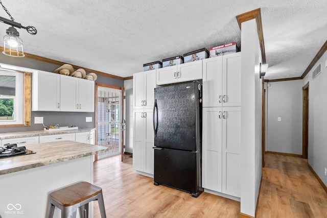 6092 N Jack Morgan Rd, Austin, IN 47102 - kitchen with freestanding refrigerator, a textured ceiling, ornamental molding, light wood-style floors, and healthy amount of natural light