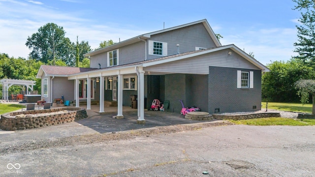 6092 N Jack Morgan Rd, Austin, IN 47102 - rear view of property featuring brick siding, a pergola, driveway, and a patio area