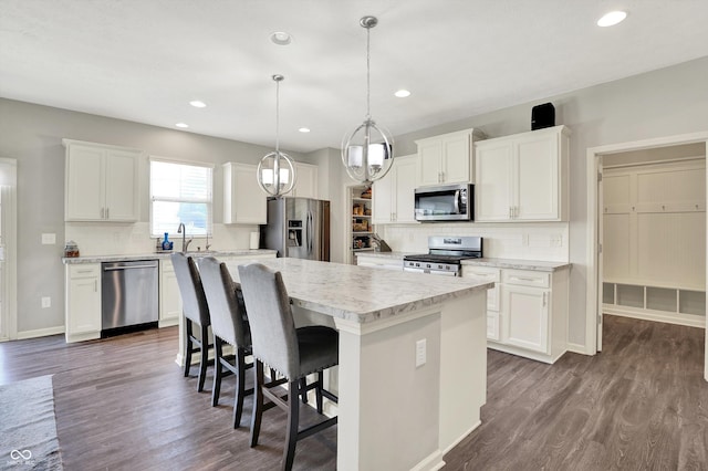 4596 Peabody Way, Westfield, IN 46062 - kitchen with appliances with stainless steel finishes, a center island, decorative backsplash, light countertops, and recessed lighting