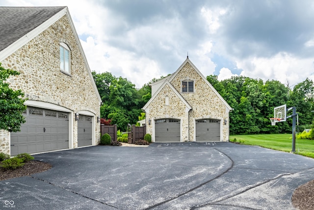 9681 Pleasant View Ln, Zionsville, IN 46077 - view of side of home with stone siding, a garage, and a yard