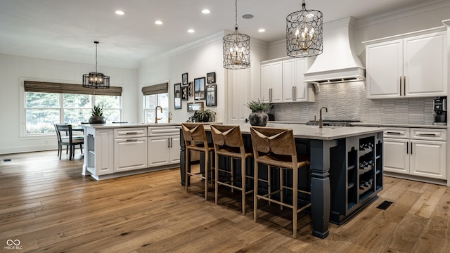 9681 Pleasant View Ln, Zionsville, IN 46077 - kitchen with an island with sink, custom exhaust hood, a chandelier, open shelves, and recessed lighting