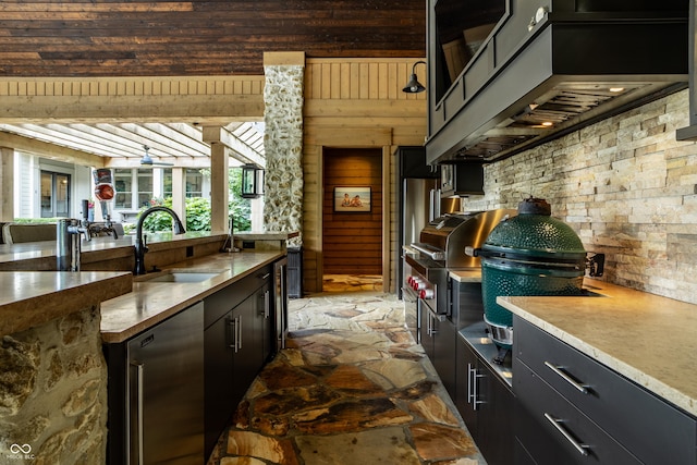 9681 Pleasant View Ln, Zionsville, IN 46077 - kitchen with stone floors, dark cabinets, wooden walls, and light countertops