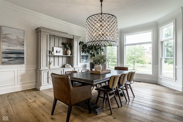 9681 Pleasant View Ln, Zionsville, IN 46077 - dining space featuring a decorative wall, light wood-style floors, crown molding, and wainscoting