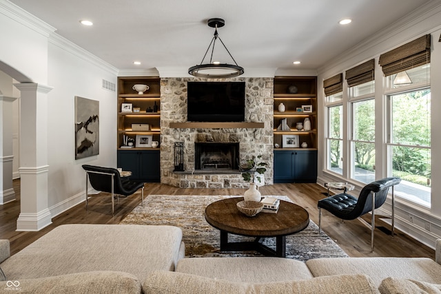 9681 Pleasant View Ln, Zionsville, IN 46077 - living room featuring crown molding, wood finished floors, a stone fireplace, built in shelves, and recessed lighting