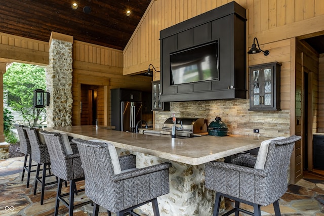9681 Pleasant View Ln, Zionsville, IN 46077 - kitchen with wooden walls, high quality fridge, high vaulted ceiling, a peninsula, and glass insert cabinets
