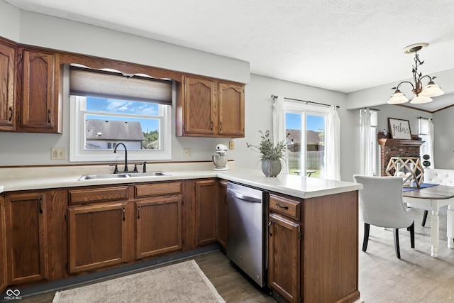 1011 Stevedon Ct, Plainfield, IN 46168 - kitchen featuring dishwasher, wood finished floors, a peninsula, light countertops, and a textured ceiling