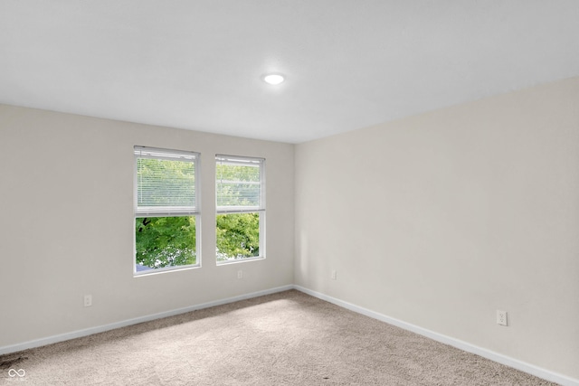 spare room featuring carpet flooring and baseboards