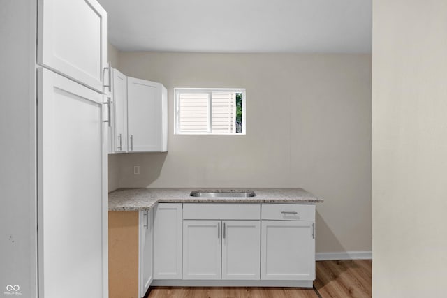 kitchen featuring light countertops, white cabinetry, and light wood-style flooring