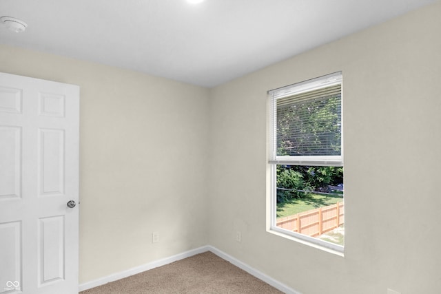 unfurnished room featuring carpet floors and a smoke detector