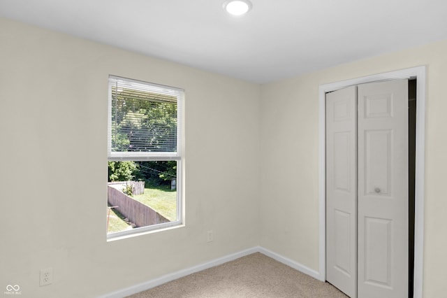 unfurnished bedroom featuring carpet flooring and a closet