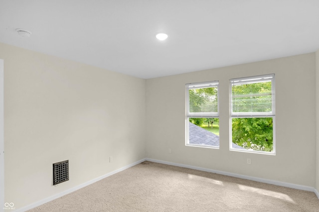 carpeted spare room featuring baseboards