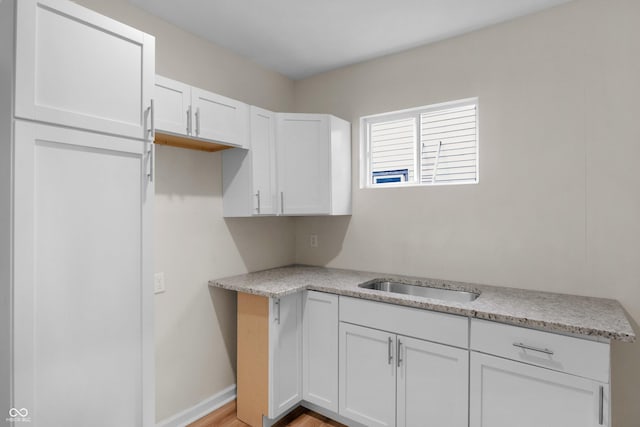 kitchen featuring white cabinets, light countertops, and light wood finished floors