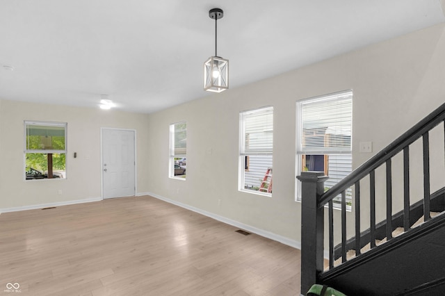 entryway with healthy amount of natural light, light wood-style floors, and stairway