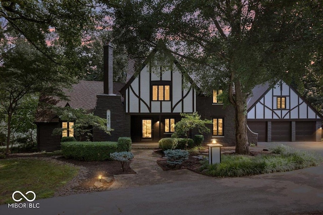 6470 Around The Hills Rd, Indianapolis, IN 46226 - tudor-style house featuring driveway, a garage, and stucco siding
