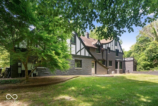6470 Around The Hills Rd, Indianapolis, IN 46226 - back of house with stone siding, a lawn, and a chimney