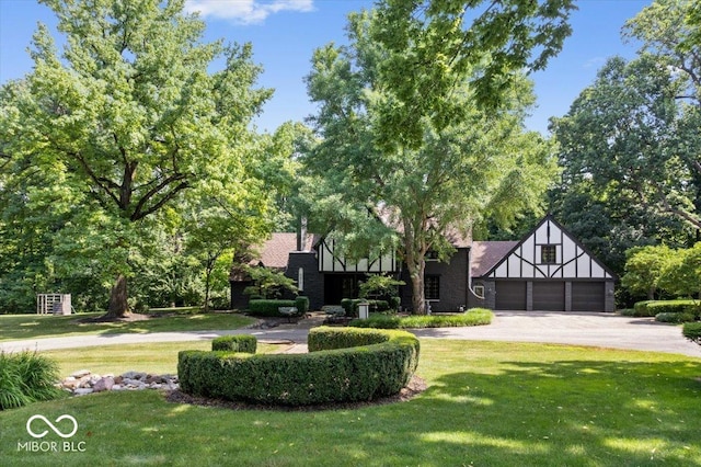 6470 Around The Hills Rd, Indianapolis, IN 46226 - english style home with a front yard, asphalt driveway, and a garage
