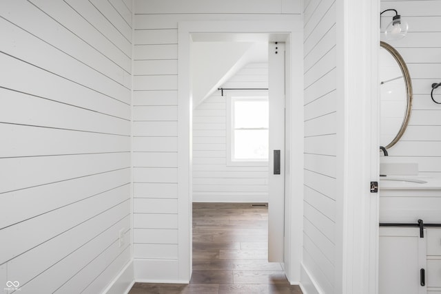 1456 Fletcher Ave, Indianapolis, IN 46203 - hallway featuring dark wood finished floors, a barn door, and wood walls