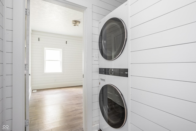 1456 Fletcher Ave, Indianapolis, IN 46203 - washroom with stacked washing machine and dryer, wood finished floors, and wooden walls