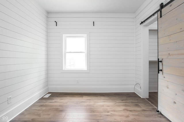 1456 Fletcher Ave, Indianapolis, IN 46203 - unfurnished room featuring a barn door and wood finished floors