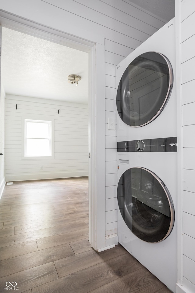 1456 Fletcher Ave, Indianapolis, IN 46203 - washroom featuring stacked washing machine and dryer and wood finished floors